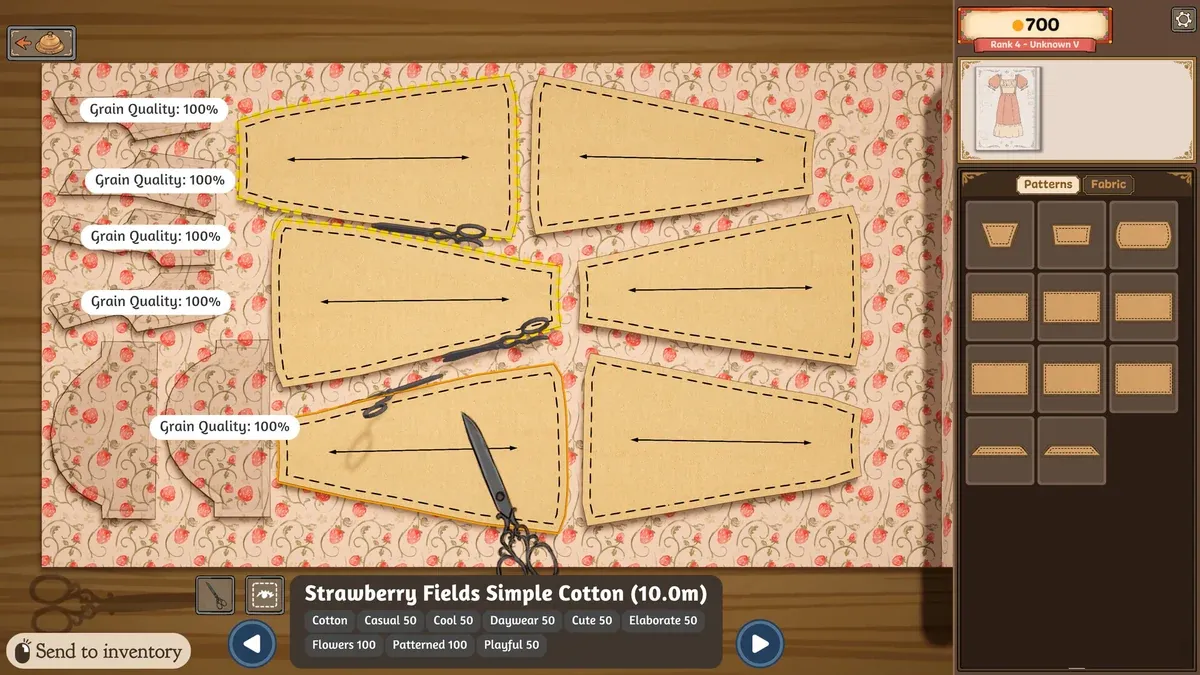 Dressmaker cutting table with paper pattern pieces laid out on printed cotton and a pair of scissors